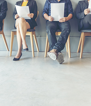 Men and women in business attire sitting in chairs